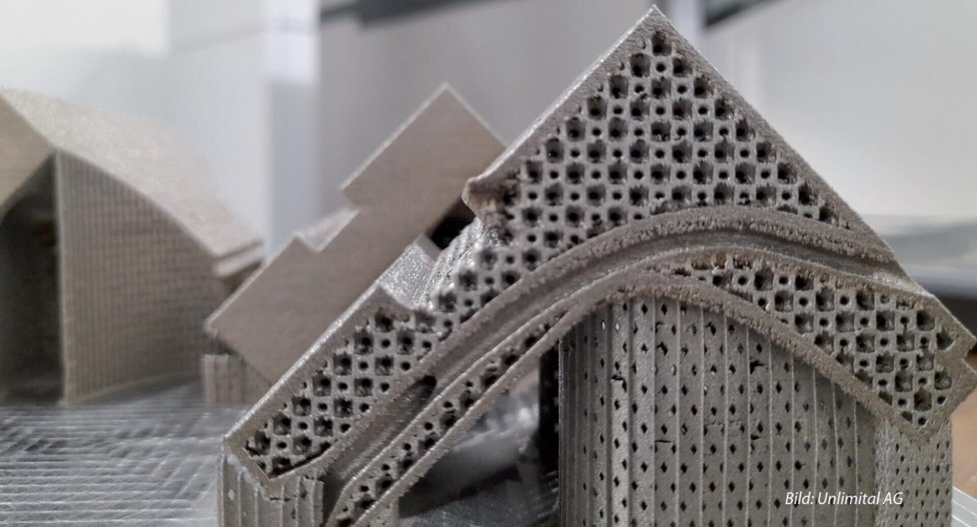 Nahaufnahme einer metallischen 3D-gedruckten architektonischen Struktur mit komplizierten perforierten Mustern und geometrischen Formen. Der Schwerpunkt des Bildes liegt auf dem detaillierten Gitterdesign des Objekts.