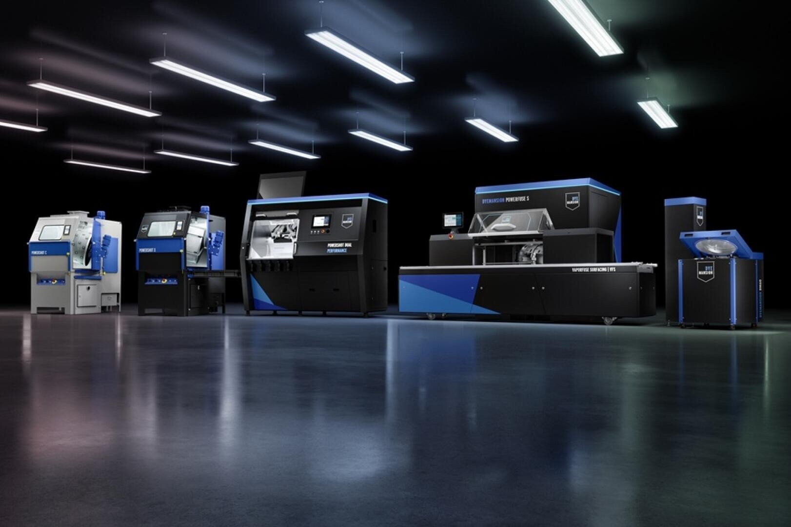 Eine Reihe fortschrittlicher, blauer und schwarzer Industriemaschinen steht in einer sauberen, modernen Fabrikhalle mit reflektierenden Böden und Deckenleuchten. Die Maschinen sind nebeneinander vor einem dunklen Hintergrund angeordnet.