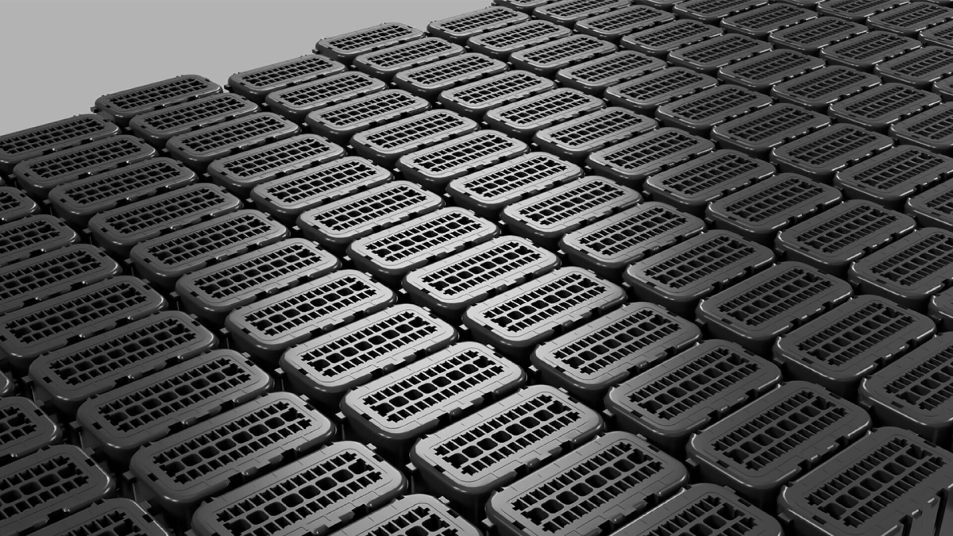 Reihen von identischen schwarzen Plastikbehältern mit gitterförmigen Deckeln sind ordentlich versetzt angeordnet, so dass ein sich wiederholendes geometrisches Muster auf dem Bild entsteht.