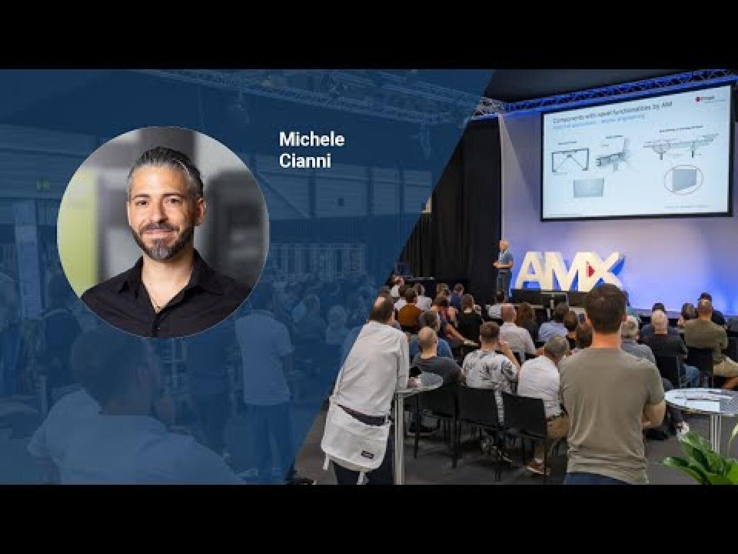 A professional event with an audience watching a speaker on stage. On the left, an overlay shows a headshot of Michele Cianni with his name. A presentation screen and the letters AMX are visible on stage.