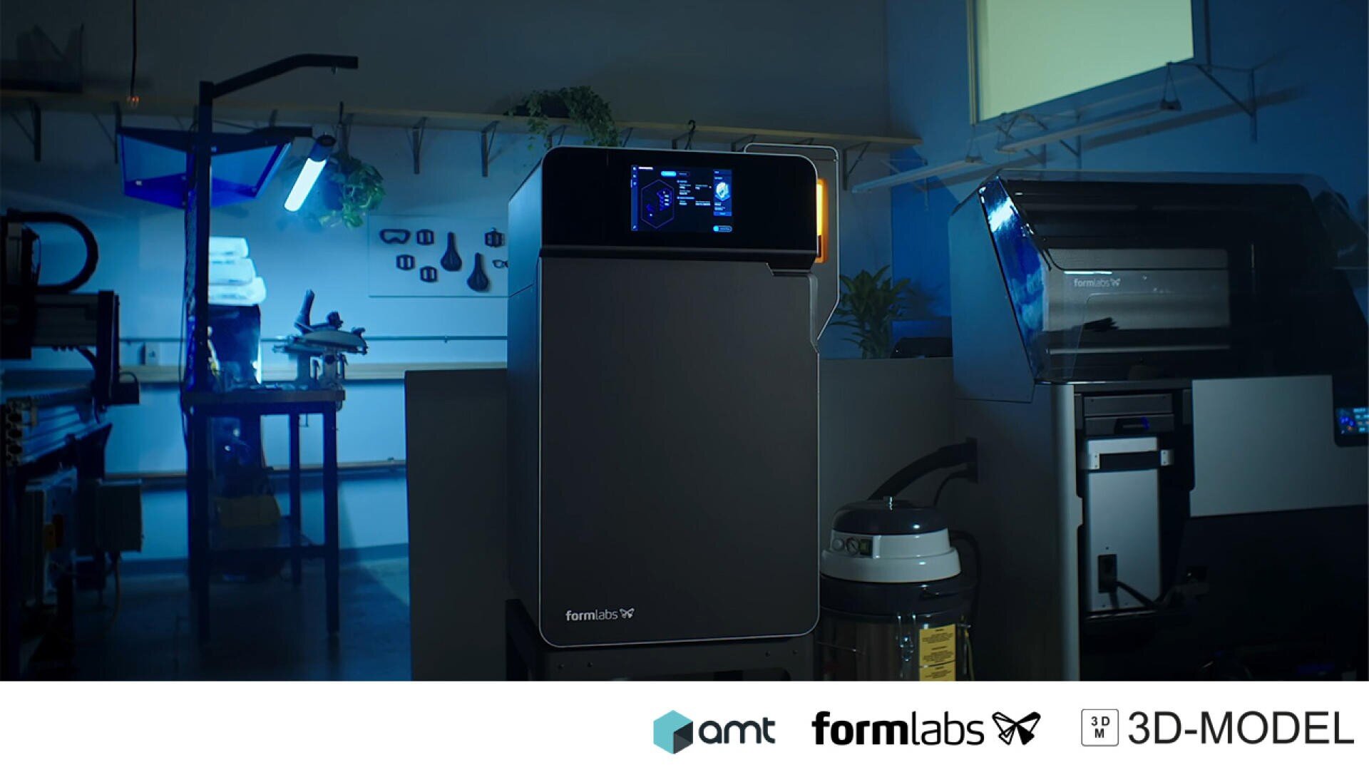Ein 3D-Drucker von Formlabs steht in einer modernen, gedämpft beleuchteten Werkstatt mit Werkzeugen an der Wand und Geräten im Hintergrund. Die Logos von amt, Formlabs und 3D-MODEL befinden sich am unteren Rand des Bildes.